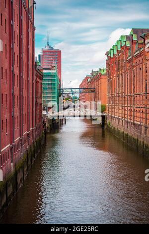 Blick auf einen Kanal in der Hamburger Speicherstadt mit Industriekletterinnen und -Kletterinnen, die die Gebäudeinstandhaltung durchführen Stockfoto