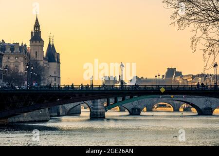 Paris, Frankreich - 1. März 2021: Wunderschöner Sonnenuntergang am Ufer der seine mit dem conciergerie-Denkmal im Hintergrund in Paris Stockfoto