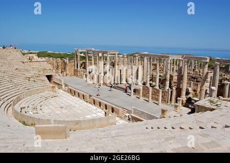 Leptis Magna, Libyen - 2. April 2006: Touristen erkunden das antike römische Theater mit Blick auf das Mittelmeer an der Küste Libyens. Stockfoto