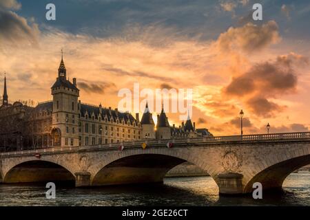 Paris, Frankreich - 14. März 2021: Wunderschöner Sonnenuntergang auf der seine mit dem Conciergerie-Denkmal im Hintergrund in Paris Stockfoto