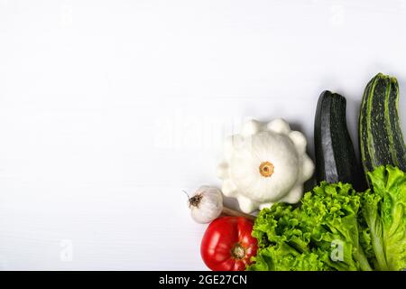 Frisches Gemüse auf weißem Holztisch. Konzept der gesunden veganen Ernährung Stockfoto