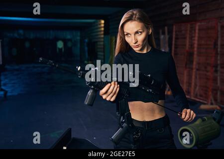 Fokussierte erfahrene Frau Scharfschütze Reinigung ihrer Waffe Stockfoto