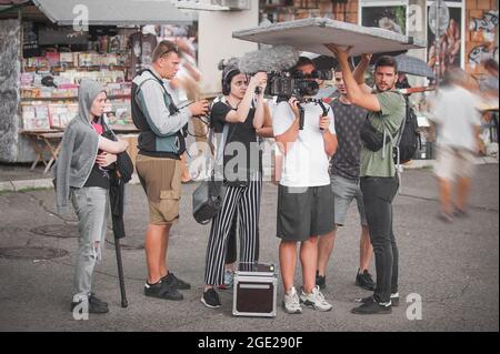 Hinter den Kulissen. Filmteam, das eine Filmszene vor Ort im Freien dreht. Gruppenfilmproduktion eingestellt Stockfoto