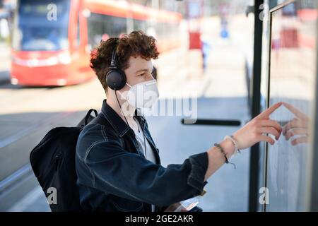 Porträt eines jungen Mannes Pendler auf Bus-Konzept im Freien in der Stadt, Coronavirus-Konzept. Stockfoto