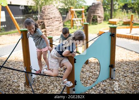 Gruppe von kleinen Kindergartenkindern, die draußen auf dem Spielplatz spielen. Stockfoto