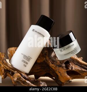 Hautpflegekosmetik der französischen Marke Academie Paris. Creme und Reiniger für die Haut auf Holz Rinde beige Hintergrund in minimalistischem Stil. Redaktionelles Produkt Stockfoto