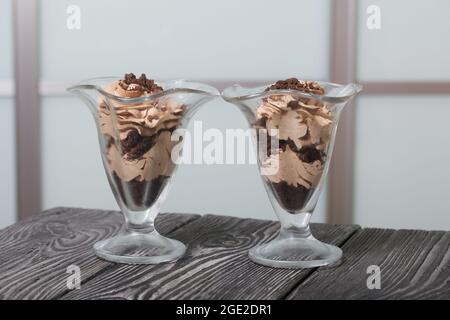 Dessert mit Rahm und Keksbröseln. Steht auf Kiefernbrettern. Nahaufnahme. Stockfoto