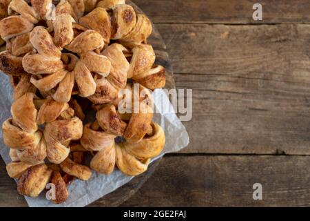 Apfel klingelt im Teig. Süße hausgemachte Kuchen. Blätterteig mit Apfelfüllung. Einfache Torte auf einem hölzernen Hintergrund. Speicherplatz kopieren. Essen zum Nachtisch Stockfoto