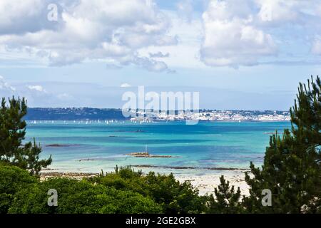 Herm, Kanalinseln, Großbritannien - 2. Juli 2016: Blick auf den Hafen von St. Peter auf Guernsey von Herm und das türkisfarbene Meer dazwischen an einem sonnigen Sommertag. Stockfoto