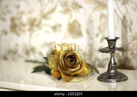 Goldene dekorative Rose unter den Wohndekorationen Stockfoto