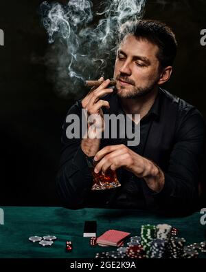 Bärtiger Casino Spieler Mann, der Poker auf dem grünen Tisch spielt Stockfoto