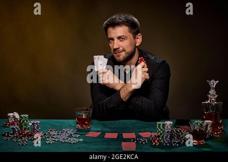 Bärtiger Casino Spieler Mann, der Poker auf dem grünen Tisch spielt Stockfoto