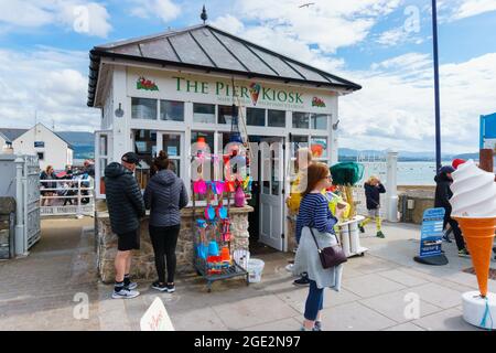 Besucher, die an einem Sommernachmittag am Beaumaris Pier in Anglesey North Wales Eis am Pier Kiosk kaufen Stockfoto