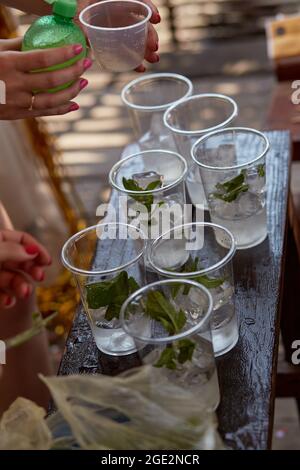 Junge Frau auf einer Junggesellinnenparty macht einen Mojito-Cocktail für die Firma. Anweisungen zur Vorbereitung. Schritt 4. Hochwertige Fotos Stockfoto