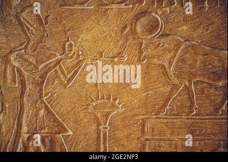 KAIRO, ÄGYPTEN - 06. Jun 2021: Eine alte ägyptische Steinoberfläche mit Schnitzereien eines pharaos, der der Stiergottheit APIs Opfergaben dargebracht hat Stockfoto