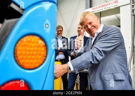 Wuppertal, Deutschland. August 2021. DGB-Vorsitzender Reiner Hoffmann betankt einen wasserstoffbetriebenen öffentlichen Bus. Der Gewerkschaftsvertreter Reiner Hoffmann besucht im Rahmen einer Sommerreise die Waste-to-Energy-Anlage. Dort wird Wasserstoff im Projekt 'H2W - Wasserstoff für Wuppertal' produziert. Seit 2020 werden Brennstoffzellenbusse des Stadtwerks Wuppertal an einer Wasserstofftankstelle betankt. Quelle: Christopher Neundorf/dpa/Alamy Live News Stockfoto