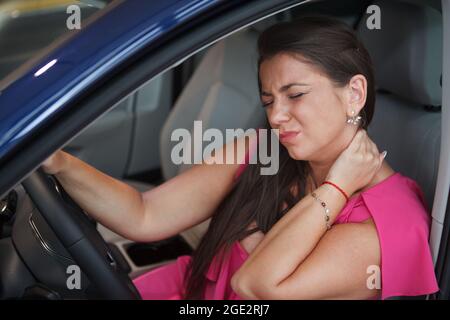 Frau mit Nackenschmerzen, müde nach langer Fahrt Stockfoto
