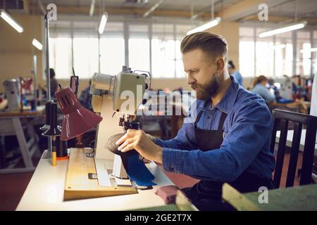 Nahaufnahme des Schusters, der mit Ledertextilien an der Nähmaschine arbeitet Stockfoto