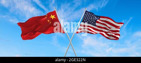 Flaggen der USA und chinas winken im Wind auf Fahnenmasten gegen den Himmel mit Wolken am sonnigen Tag. Symbolisieren Beziehung, Dialog zwischen zwei Ländern Stockfoto