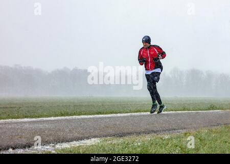 Die Niederlande, Hilversum, Runner, Jogger im Schneesturm. Winter. Stockfoto