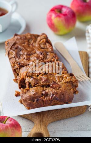 Apfelbrot auf einem Holzbrett. Herbstkuchen mit Früchten, grauer Hintergrund. Stockfoto