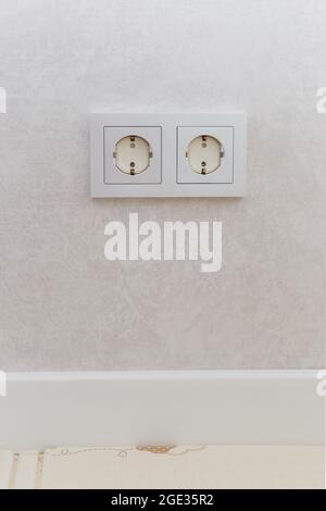 Steckdose an der Wand mit Sicherheitssteckern zum Schutz vor Kindern abgedeckt Stockfoto