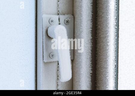 Das Thema des Einfrierens von Haus Kunststoff-Fenster im Haus aufgrund des Alters. Das Konzept der Fensterisolierung vor dem Winter. Stockfoto