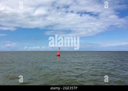 Eine rote Boje an der Nordsee im ostfriesischen Wattenmeer vor der Juist-Insel, Deutschland. Stockfoto