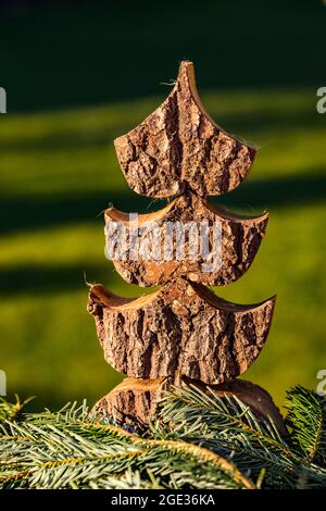 Ein ausgeschnittener Weihnachtsbaum aus Holz vor einem natürlichen Hintergrund ist eine schöne Dekoration für Weihnachten Stockfoto