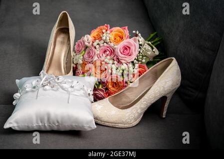 Schöne Hochzeitsschuhe Frau mit Blumenstrauß und Eheringe Stockfoto