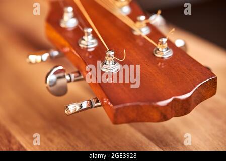 Gitarre Kopfplatte auf einer Holzoberfläche. Horizontales Nahaufnahme-Bild mit selektivem Fokus. Stockfoto