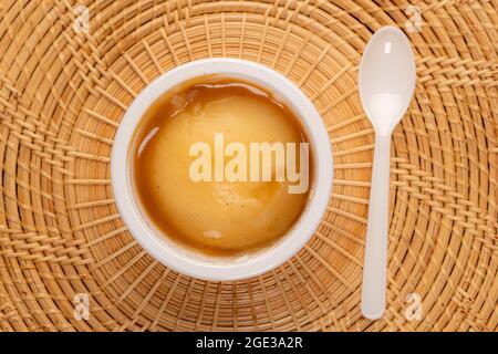 Homemadw Kartoffelpüree mit Soße in weißem Eimer isoliert auf Holzmatratzen. Stockfoto