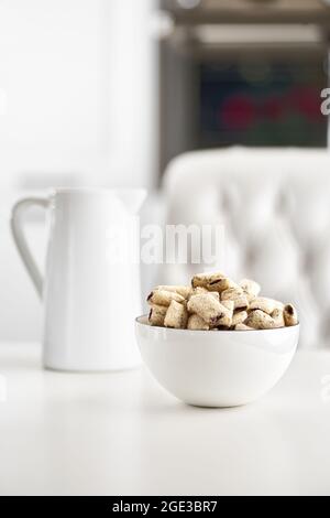 Trockene Frühstücksflocken mit Milch auf einem hellen Tisch. Selektiver Fokus Stockfoto