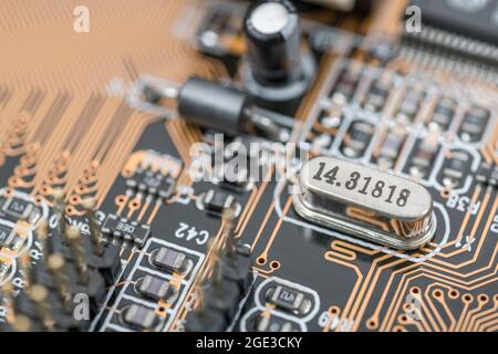 Quarzkristall-Oszillator-Resonator auf einer PB-Hauptplatine. Oszillatoren liefern anderen cCmponenten in einem elektrischen System einen elektrischen „Herzschlag“. Stockfoto