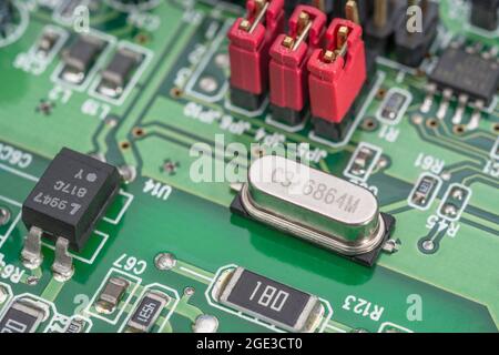 Quarzkristall-Oszillator-Resonator auf einer leiterplatte. Oszillatoren geben anderen Komponenten in einem elektrischen System einen elektrischen „Herzschlag“. Stockfoto