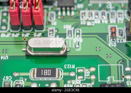 Quarzkristall-Oszillator-Resonator auf einer leiterplatte. Oszillatoren geben anderen Komponenten in einem elektrischen System einen elektrischen „Herzschlag“. Stockfoto