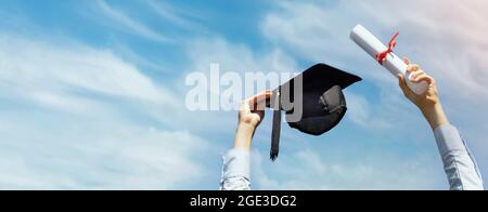 Absolvent mit Diplom und Kappe in den Händen auf blauem Himmel Hintergrund feiert College-Abschluss. Banner kopieren Raum Stockfoto