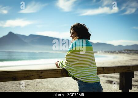 Frau mit gemischter Rasse, die an einem sonnigen Tag am Meer steht Stockfoto