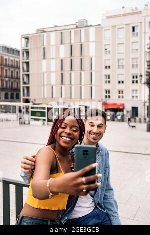 Glückliche junge Freunde, die ein Selfie mit ihrem Handy auf der Straße machen und Spaß haben. Stockfoto