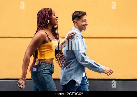 Nettes junges Paar in legerer Kleidung, das sich in den Straßen von Madrid amüsieren und spazieren gehen kann. Stockfoto