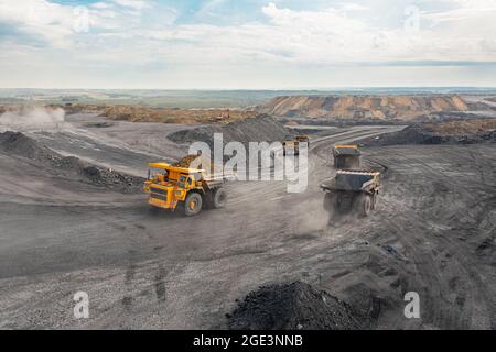 Großer Steinbruch Muldenkipper. Großer gelber Bergbauwagen auf der Baustelle. Laden von Kohle in den LKW. Produktion nützlicher Mineralien. Bergbau LKW Bergbau Maschinen Stockfoto