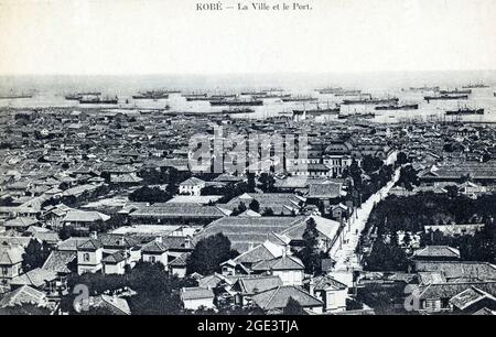 Alte japanische, handkolorierte Postkarte, um 1910, Luftaufnahme des geschäftigen Hafens von Kobe. Kleine Häuser im Vordergrund, Schiffshafen im Hintergrund Stockfoto