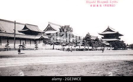 Alte Postkarte, um 1910, vom Higashi Honganji Tempel in Kyoto. Breite Straße vor, von baumgesäumten Wänden, mit Tempelgebäuden dahinter. Monochrom. Stockfoto