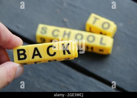 Zurück zur Schule. Inschrift aus gelben Würfeln. Kreatives Konzept. Stockfoto