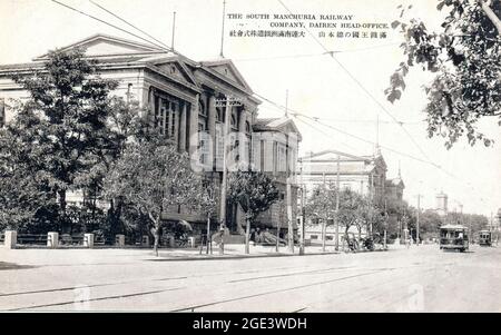 Alte monochrome japanische Postkarte um 1910-20 der Hauptniederlassungen der South Mandschuria Railway Company, mit Straßenbahn davor. Dairen, China. Stockfoto