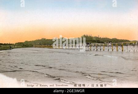 Alte, handkolorierte japanische Postkarte, um 1900, einer hölzernen Brücke über den Katase-Fluss zur kleinen Insel Yenoshima. Stockfoto