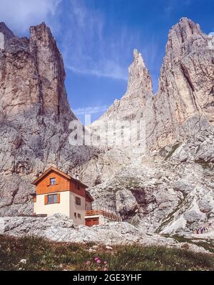 Dies ist die private Berghütte Preuss in der Nähe der imposanten Gipfel der Vajolet-Türme in der Rosengarten-Dolomiten-Region der italienischen Dolomiten, Südtirol. Filmbegeisterte werden sich daran erinnern, dass die Vajolet-Türme in den Eröffnungsszenen von Sylvester Stallone's Film Cliffhanger waren, als eine junge Frau aus der Lücke zwischen dem zweiten und dritten Turm, die rechts oben auf dem Foto zu sehen ist, in den Tod fiel. Stockfoto