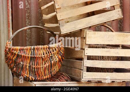 Gestrickter Korb und Holzkisten auf der Straße Stockfoto