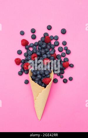 Frische Früchte in einem knusprigen Waffelkegel auf rosa Hintergrund Stockfoto