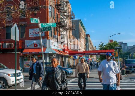 Geschäfte und Gebäude in der Harlem Street am Malcolm X Boulevard und der Lenox Avenue in Harlem in Manhattan in NYC, USA Stockfoto